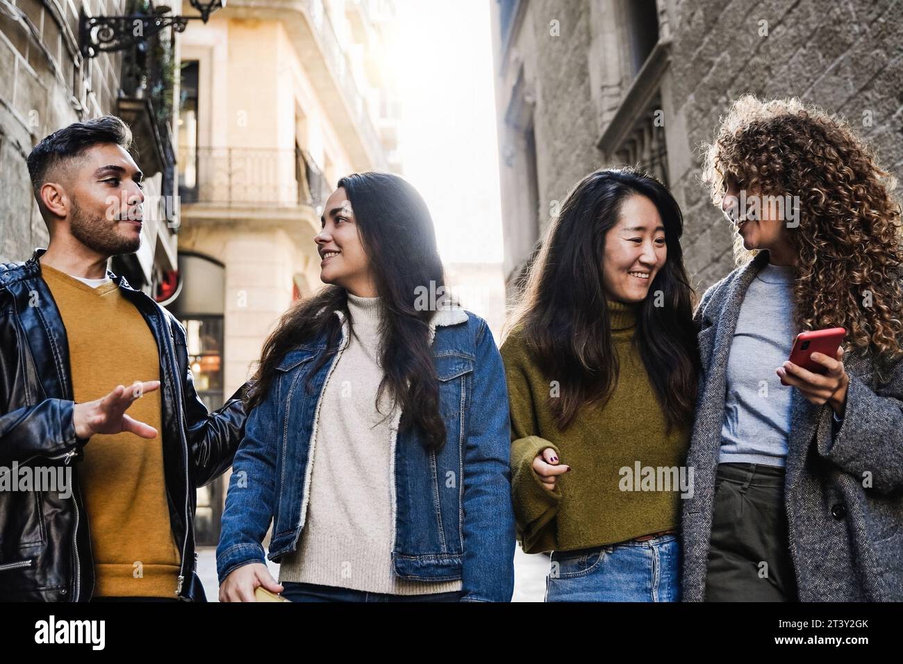 Verschiedene Gruppen von Leuten, die Spaß in der Stadtstraße haben. Multirassische Touristenfreunde genießen den Urlaub im Winter Stockfoto