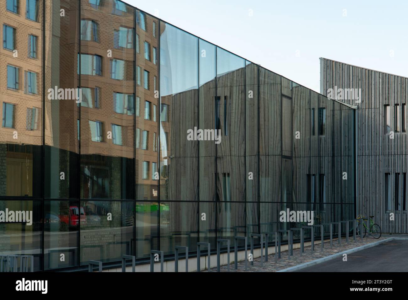 Blick auf die verglasten Fassadenkonstruktionen mit UV-Schutz in der modernen Architektur. Holz, Glas, Metall und Ziegel werden als Bauelement verwendet Stockfoto