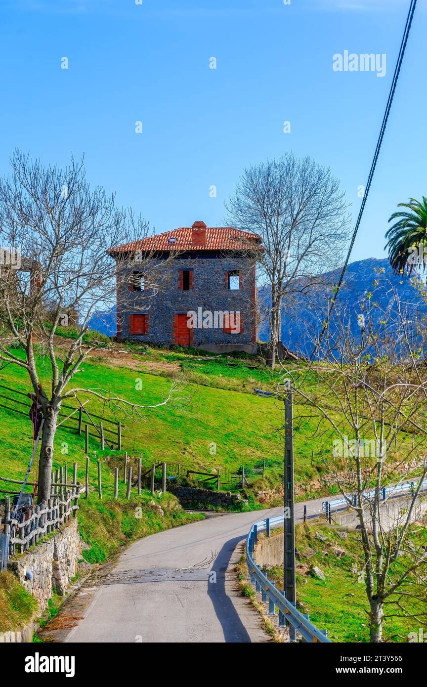 Schmale Landstraße und ein Gebäude in der Ferne. Cofino Town ist eine ländliche Siedlung in einem wunderschönen Tal. Stockfoto