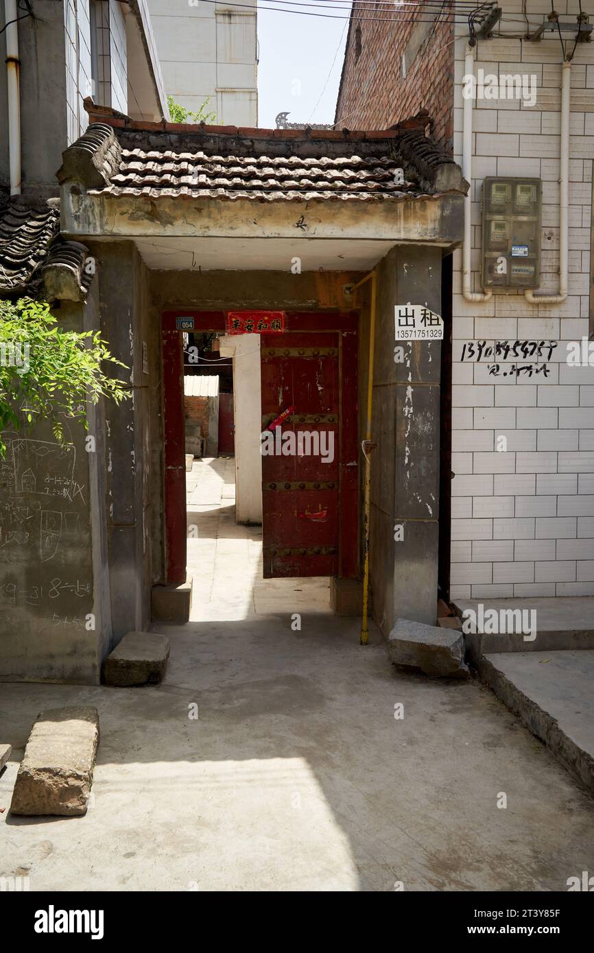 Eine traditionelle Holztür im Bezirk Qishan, Provinz Shaanxi, China, mit einem roten Couplet auf dem Sturz, der „Frieden und Harmonie“ wünscht. Stockfoto