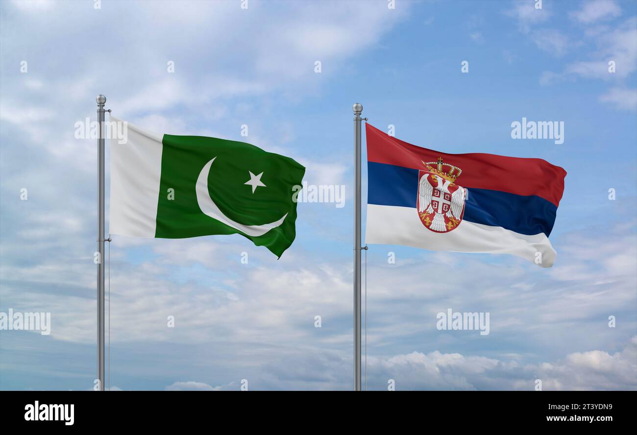 Die Flagge der Republik Serbien und Pakistan winkt zusammen im Wind auf blauem bewölktem Himmel, zwei Länder-Beziehungskonzept Stockfoto