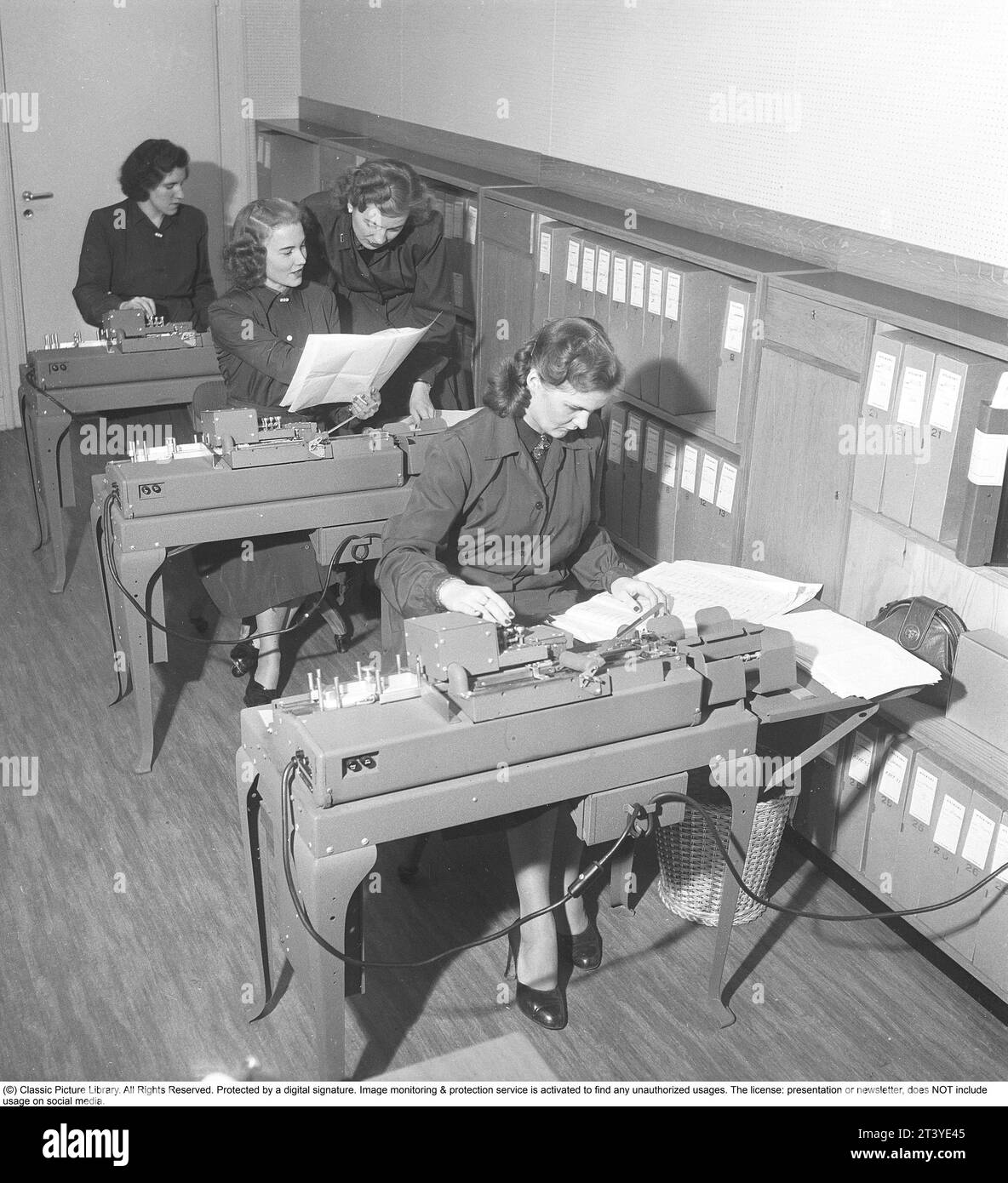 In den 1950er Jahren Weibliche Angestellte an Punschkarten-Maschinen geben Informationen ein, die in Punschkarten übertragen werden. Lochkarten waren ein Speichermedium, bei dem die Lochlöcher in der Papierkarte die Eingabeinformationen waren, und die Löcher und Informationen wurden dann von einer anderen Maschine, einem Lochkartenleser, gelesen und die Informationen dann organisiert oder gedruckt werden konnten. Schweden 1950. Kristoffersson Ref. BA87-8 Stockfoto