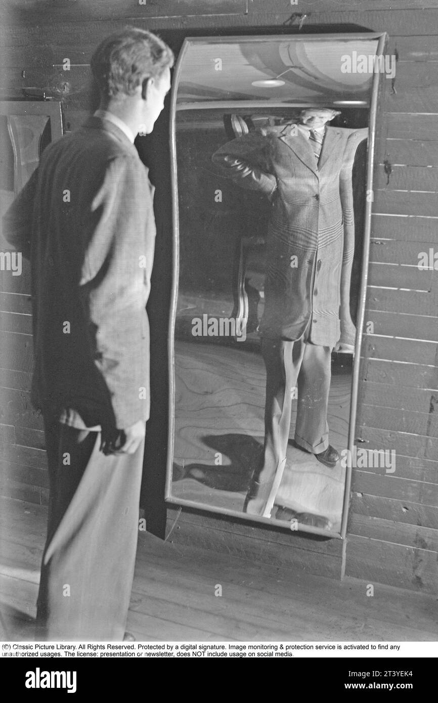 Åke Ödmark , 1916-1994 , schwedischer Hochspringer und schwedischer Rekordhalter im Hochsprung in den Jahren 1939-1946 mit einer Höhe von 2 Metern. Geehrt mit Big Boys Abzeichen Nr. 98. Hier in Skrattkammaren bei Gröna Lund, wo er sich in einem lachenden Spiegel sieht. Normale Spiegel haben eine flache Oberfläche, während dieser Spiegel sowohl nach innen als auch nach außen gewölbt, konkav und konvex ist. Der Spiegel lässt einen hoch und dünn aussehen. Andere spiegeln kurz und dick. Gröna Lund Stockholm Schweden Juli 1940. Kristoffersson Ref. 153-10 Stockfoto
