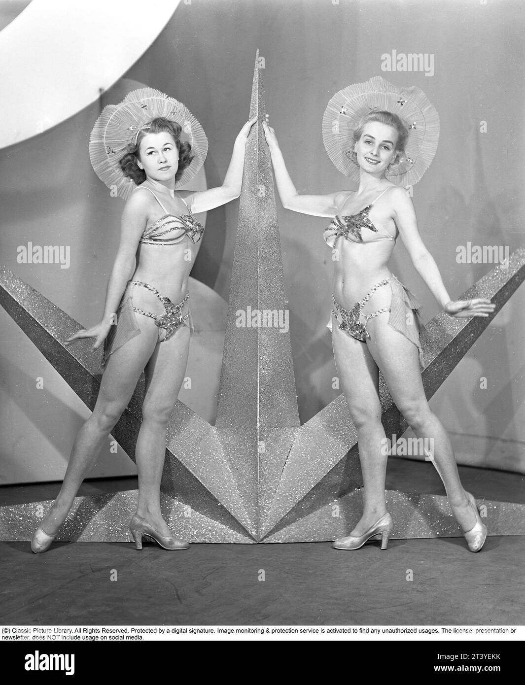 In den 1940er Jahren Zwei junge Frauen aus dem Theaterensemble der Södra teatern in Stockholm sind in Bühnenkleidung gekleidet, ähnlich wie ein Bikini, auf der Bühne neben einem Stern, der dort während der Revue-Performance als Dekoration platziert wurde. Schweden 1945. Kristoffersson Ref. 89A-11 Stockfoto