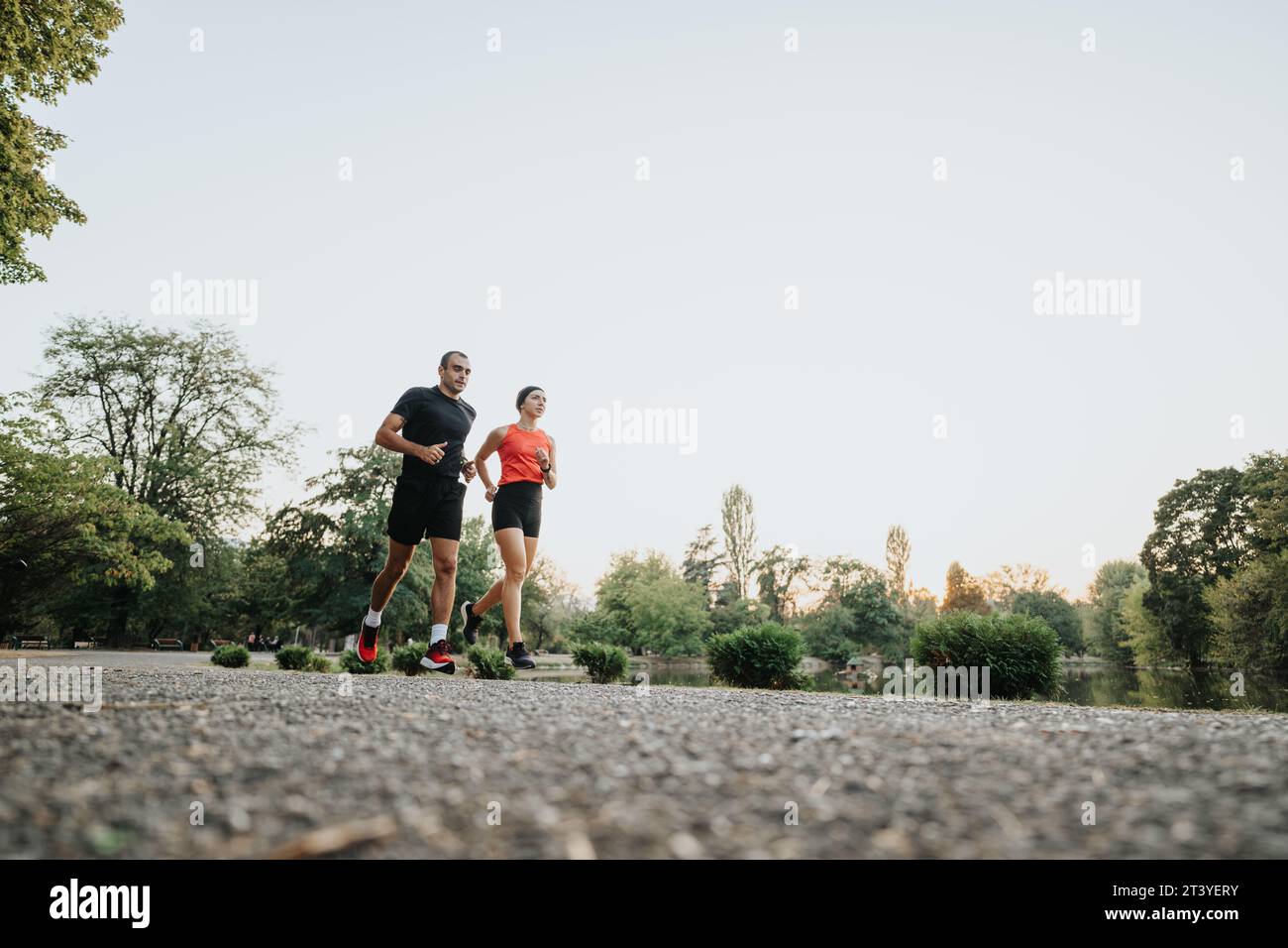Ein Paar joggt in Sportbekleidung durch den Park. Stockfoto