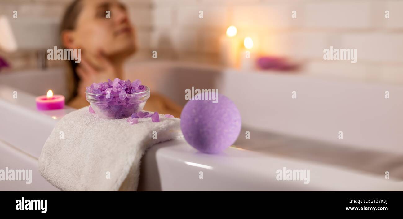Frau genießt Badewanne mit Meersalzkristallen und Badebombe. Heim-Spa. Banner mit Kopierbereich Stockfoto