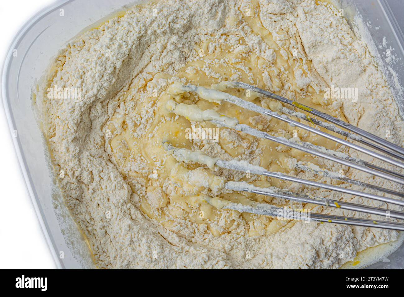 Teig in der Schüssel und Schneebesen auf weißem Hintergrund von oben Stockfoto