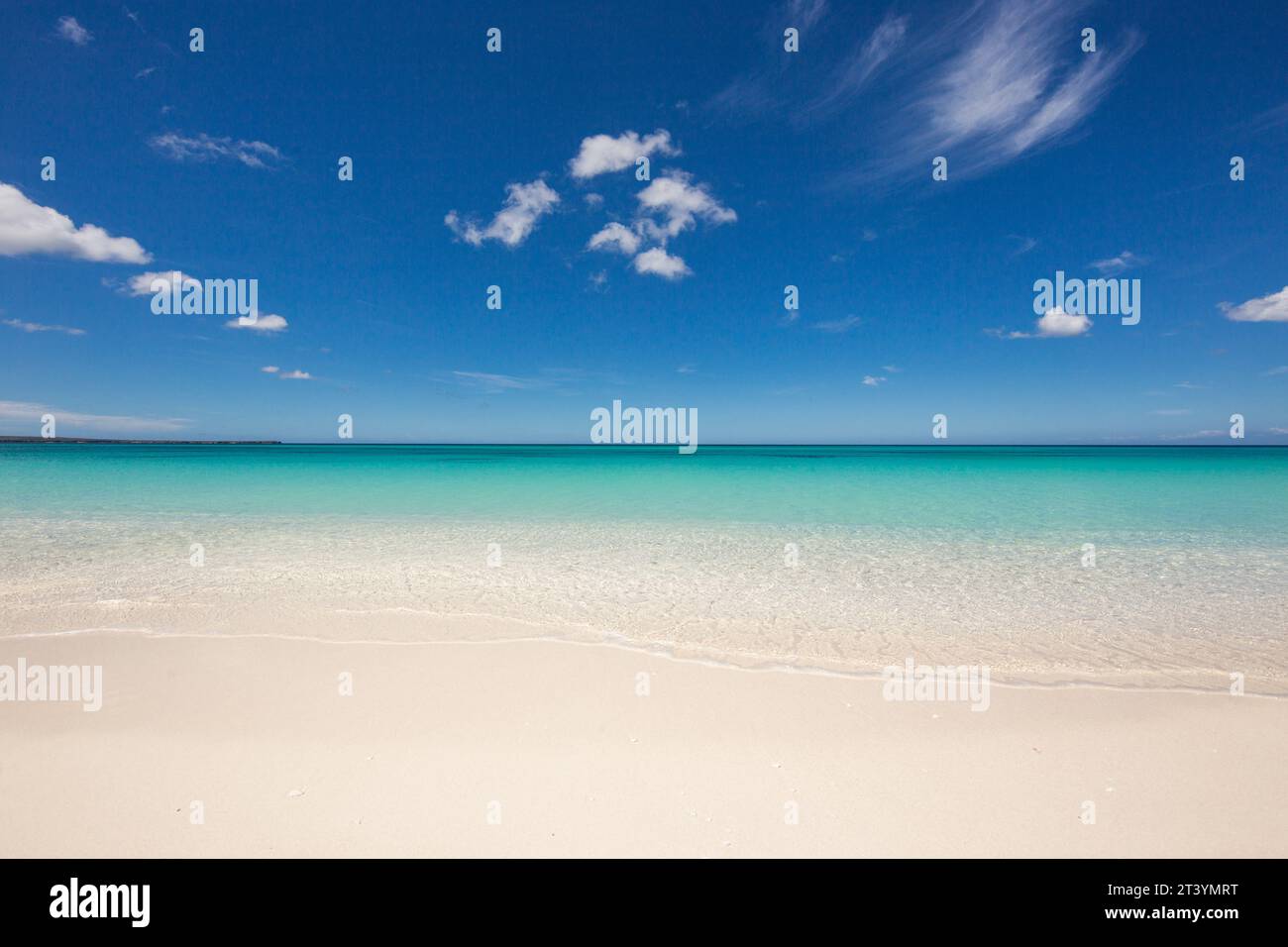 Wilder Strand mit weißem Sand und klarem Wasser. Winken Sie im Sand und im blauen Himmel. Die besten Strände der Welt Stockfoto