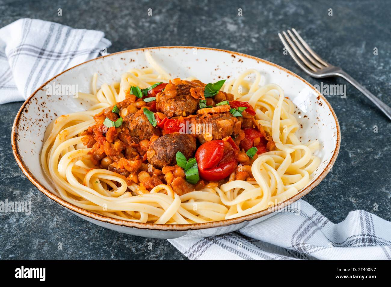 Fleischbällchen in Tomaten- und Linsensauce mit Linguinnudeln Stockfoto