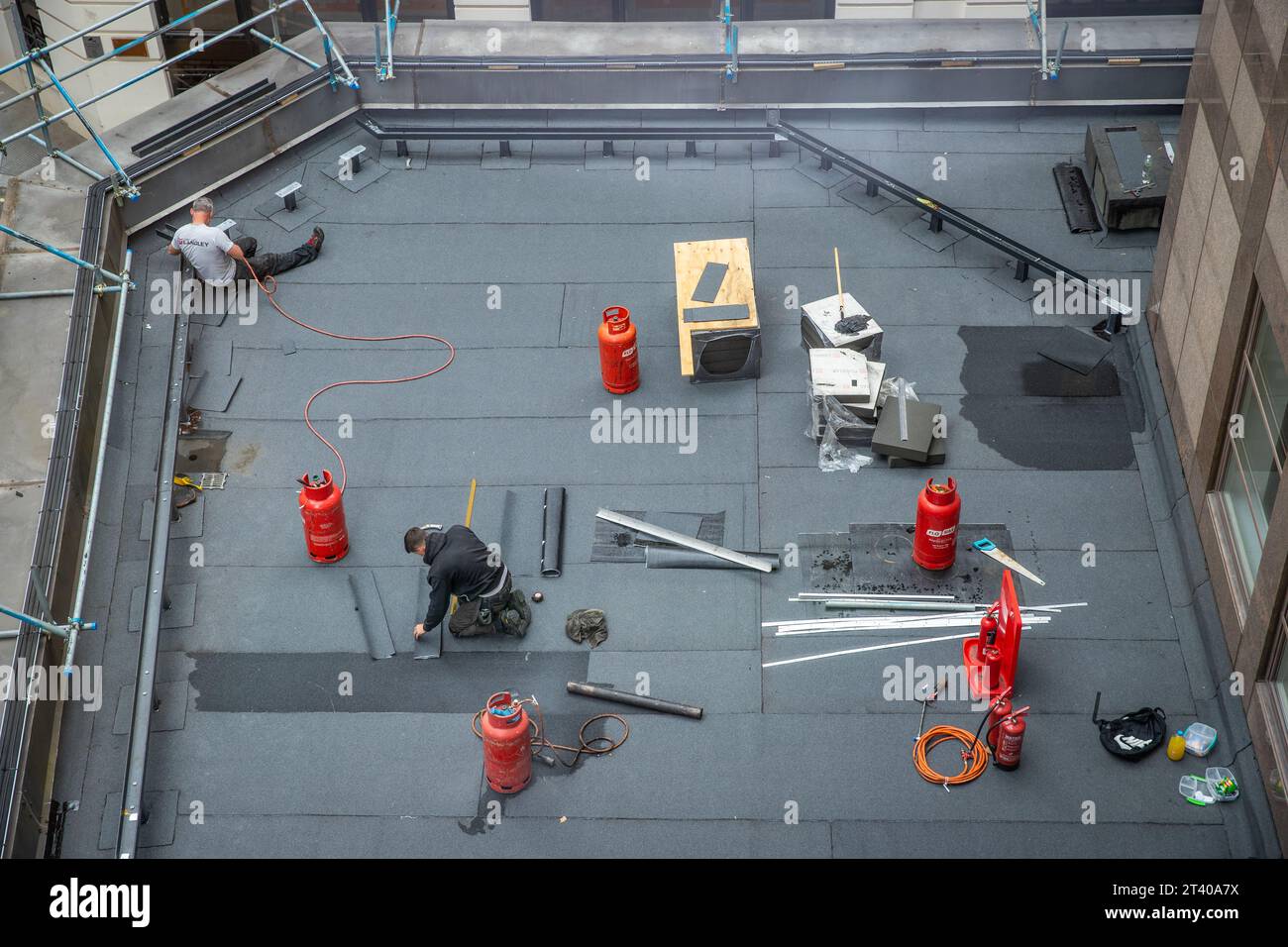 Dachdecker repariert ein Flachdach von oben Stockfoto