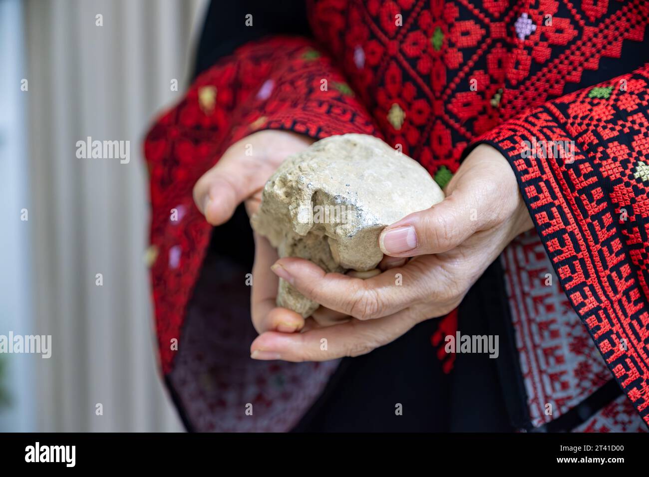 Eine Palästinenserin hält einen Stein in den Händen, der die einzige Waffe darstellt, die der Besatzung widersteht Stockfoto