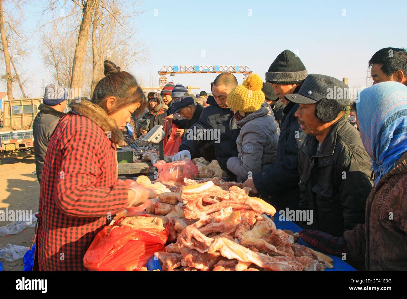 LUANNAN COUNTY - 28. JANUAR: Der Kunde und Verkäufer, der am 28. januar 2014 vor einem Fleischstand verhandelt wurde, Luannan County, Provinz Hebei, China. Stockfoto