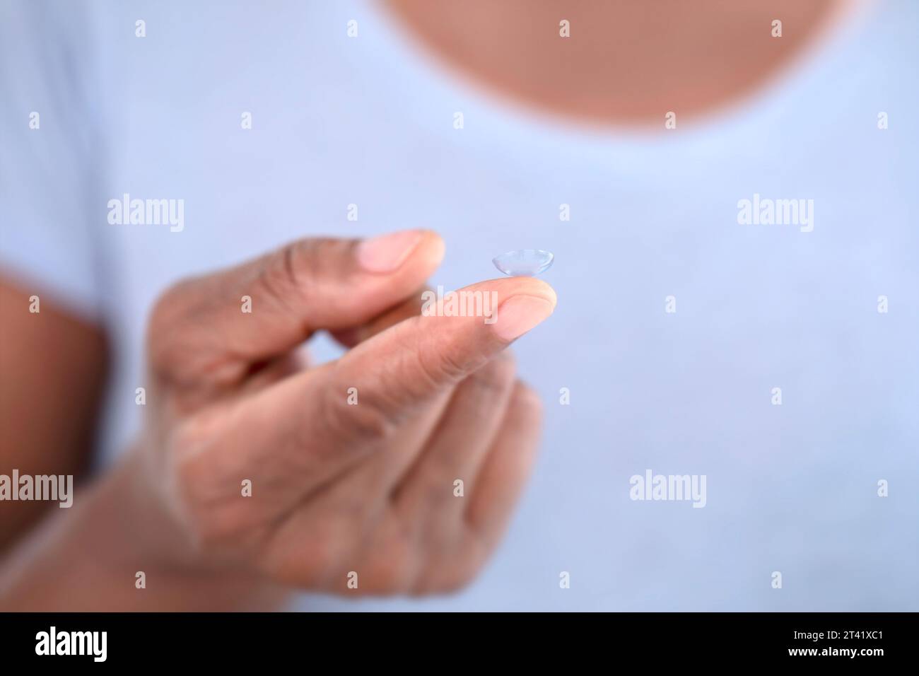 Kontaktlinse am Finger der Frau Stockfoto