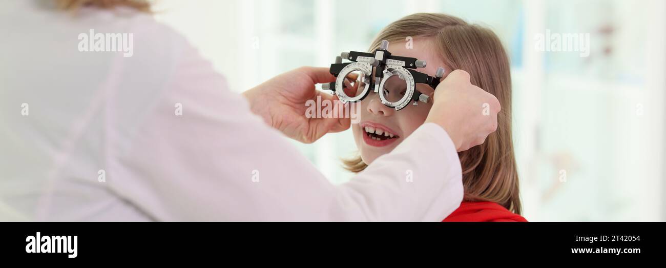 Der Arzt setzt eine Augenbrille auf das Mädchen, um das Sehvermögen zu überprüfen Stockfoto