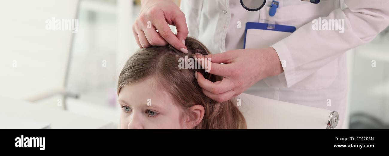 Der Therapeut sucht nach Insekten im Haar des kleinen Patienten Stockfoto