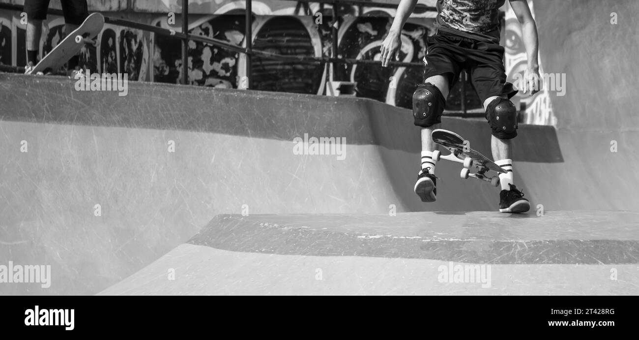 Eine Schwarzweißaufnahme eines Skateboarders, der im Skatepark übt. Stockfoto