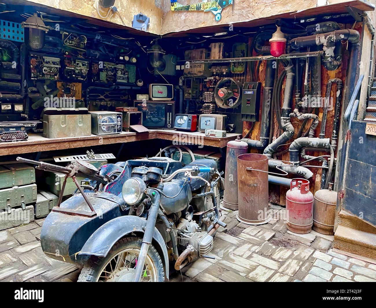 Ein antikes Motorrad aus vergangener Zeit wird in einer schwach beleuchteten Garage ausgestellt, die ein nostalgisches Flair vermittelt Stockfoto