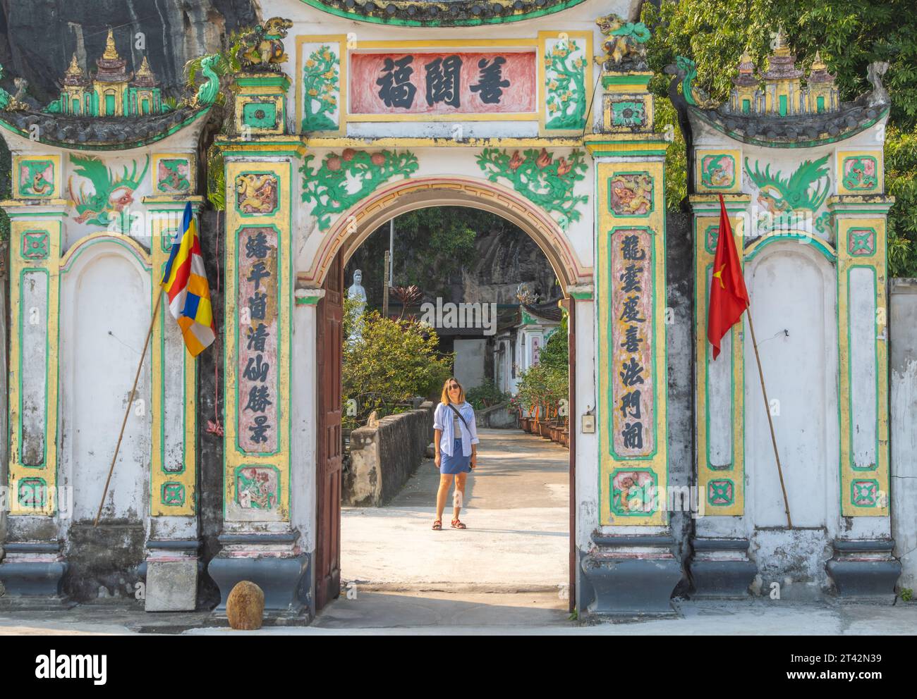 Ein Mann, der vor einem offenen Steinbogen in einer asiatischen Umgebung steht Stockfoto