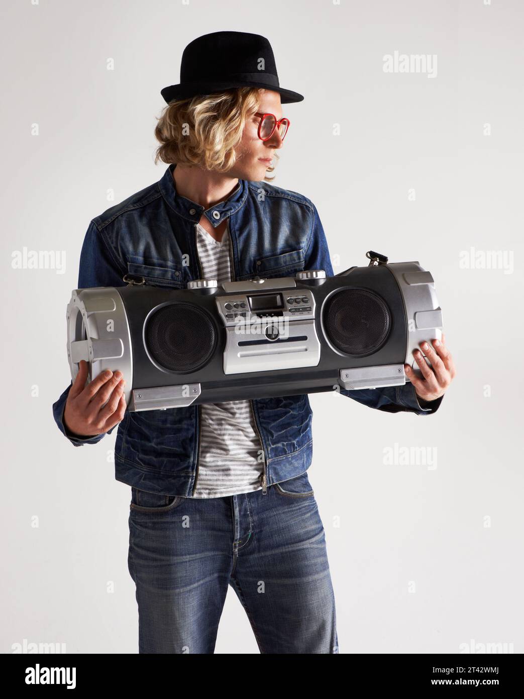 Boombox, Mode und Retro-Stil eines Mannes im Studio mit Musik, Radio oder Audio Sound und Lärm. Männliches Model auf weißem Hintergrund mit Denim Stockfoto