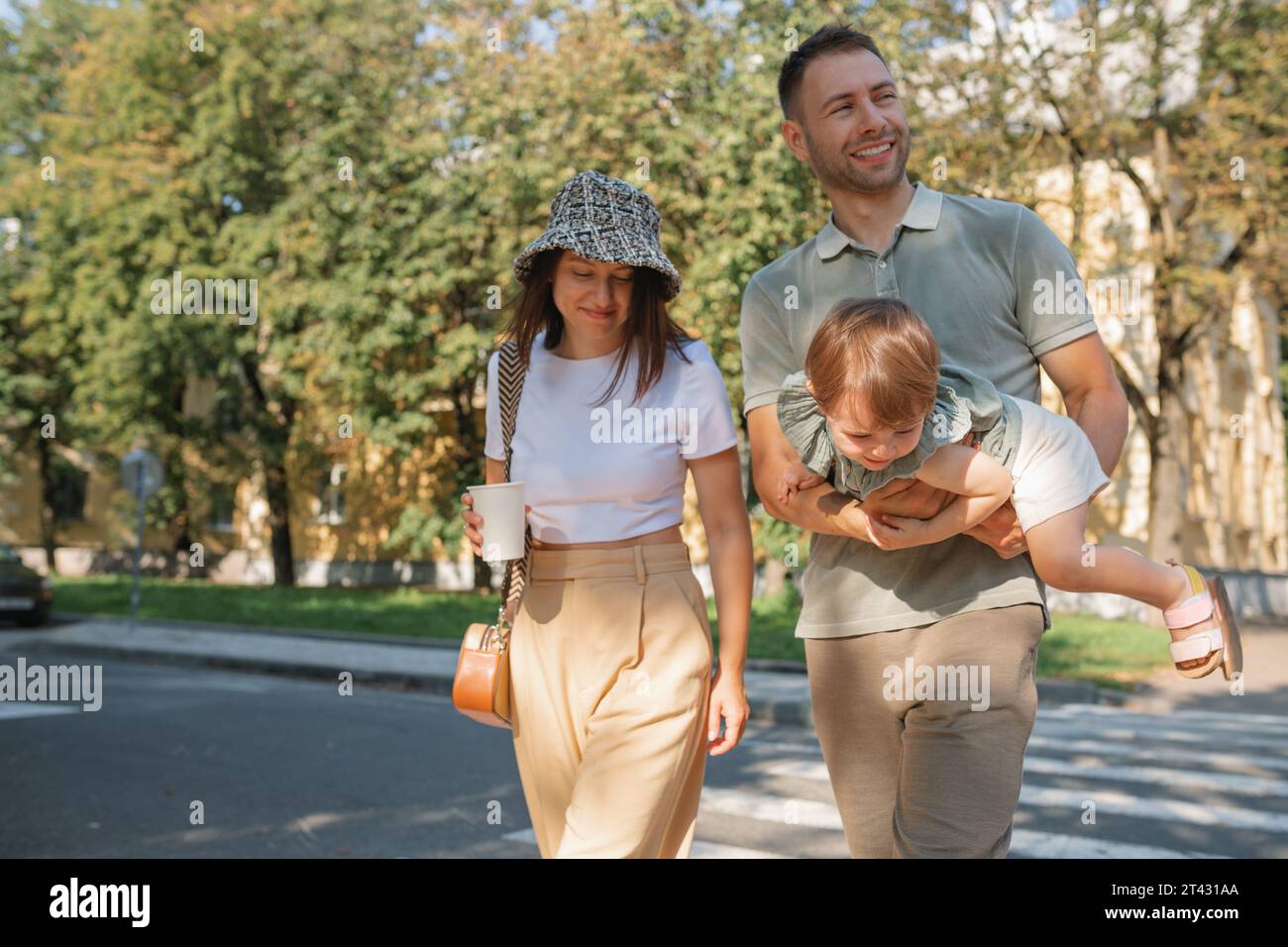 Mutter und Vater gehen mit ihrer Tochter Weißrussland die Straße entlang Stockfoto