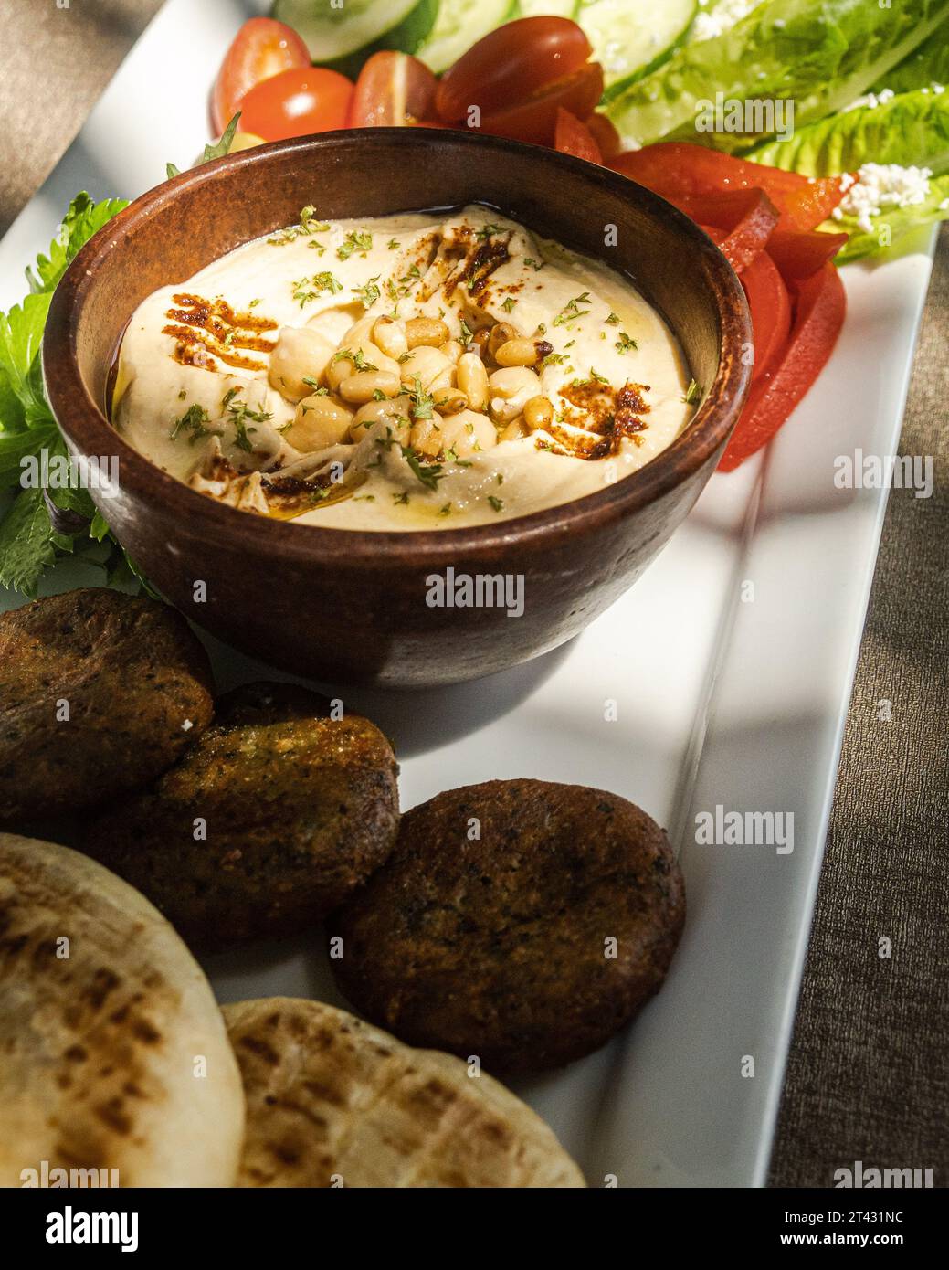 Nahaufnahme einer Meze-Platte mit Fladenbrot, Hummus, Falafel, Oliven, Tomaten, Gurke und Salat Stockfoto