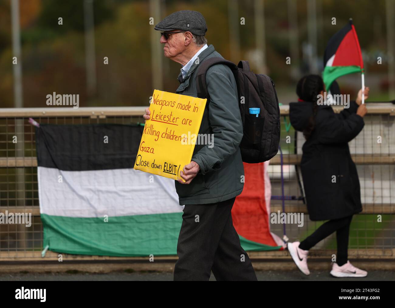 Leicester, Leicestershire, Großbritannien. Oktober 2023. Ein Demonstrant trägt ein Banner, das die Schließung von Elbit während einer pro-palästinensischen Demonstration fordert, und einen Banner-Drop in der Nähe der Basis der taktischen UAV-Systeme. ElbitÕs UAV Tactical Systems ist ein israelisch-französisches Unternehmen, das Drohnen herstellt, die an die britische Armee, Israel und internationale Waffenmärkte verkauft werden. Credit Darren Staples/Alamy Live News. Stockfoto