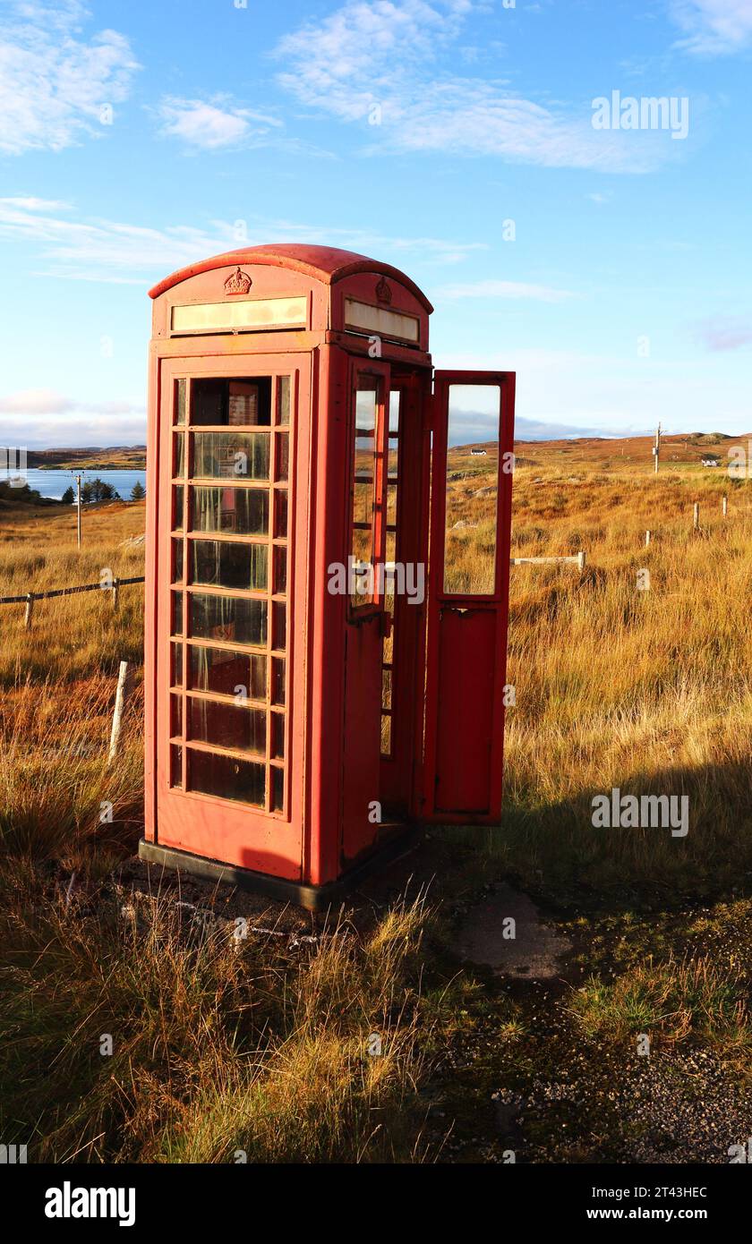 Eine verwitterte rote Telefonbox in abgeschiedener Straßenlage auf der Isle of Lewis, Äußere Hebriden, Schottland, Vereinigtes Königreich. Stockfoto