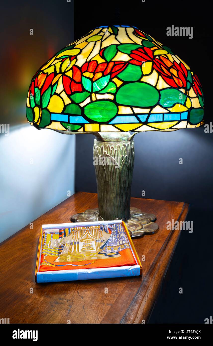 Reproduktion Tiffany-Lampe mit Acrylschirm und Hermes Schal auf einer Cherrywood-Tischplatte. Stockfoto