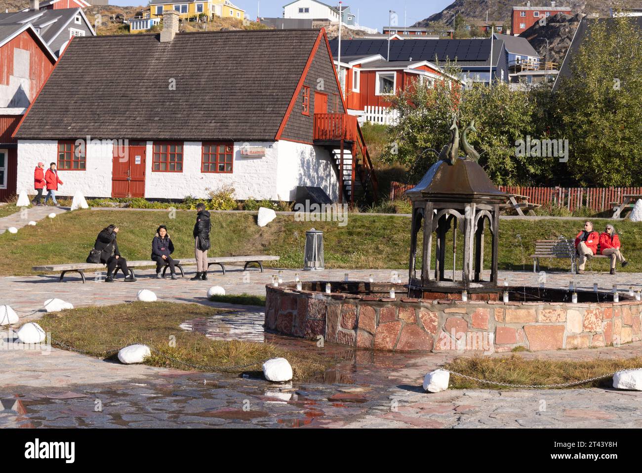 Qaqortoq Grönland - Touristen und Einheimische im Stadtzentrum und berühmten Gedächtnisbrunnen; Qaqortoq, Südgrönland, Arktis. Stockfoto