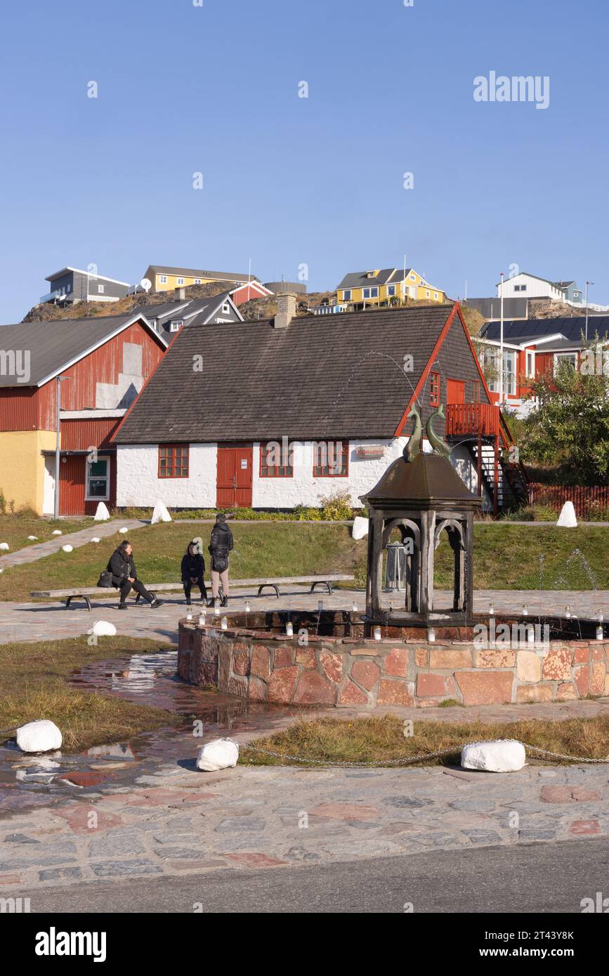 Qaqortoq Grönland - Einheimische inuit im Stadtzentrum und berühmte Gedenkbrunnen; Qaqortoq, Südgrönland, Arktis. Stockfoto