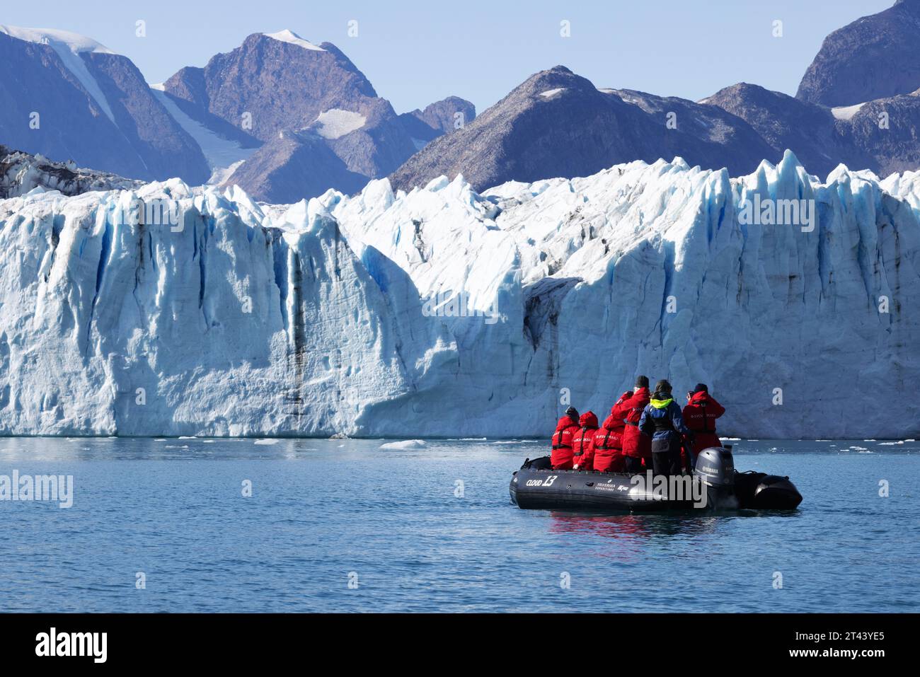 Grönlandgletscher - Menschen in einem Schlauchboot mit Tierkreiszeichen, die einen Blick auf den Thrym-Gletscher, den Skjoldungen-Fjord, Ostgrönland aus nächster Nähe haben. Polarbewegung. Stockfoto