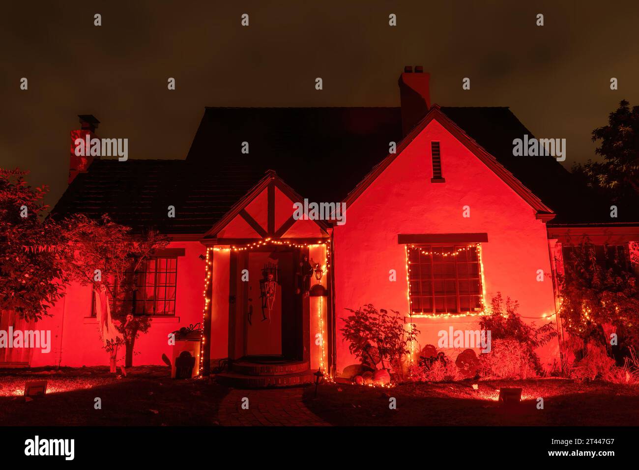 Rot beleuchtetes Halloween-Haus mit unheilvollem Nachthimmel Stockfoto
