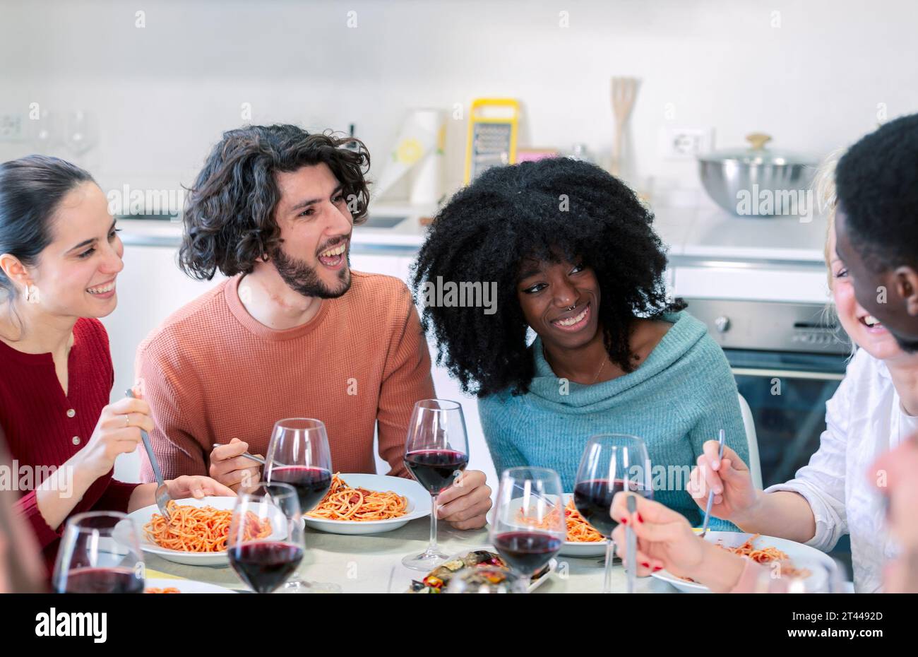 Multiethnische Freunde treffen sich zum Mittagessen, um italienische Speisen zu essen Stockfoto