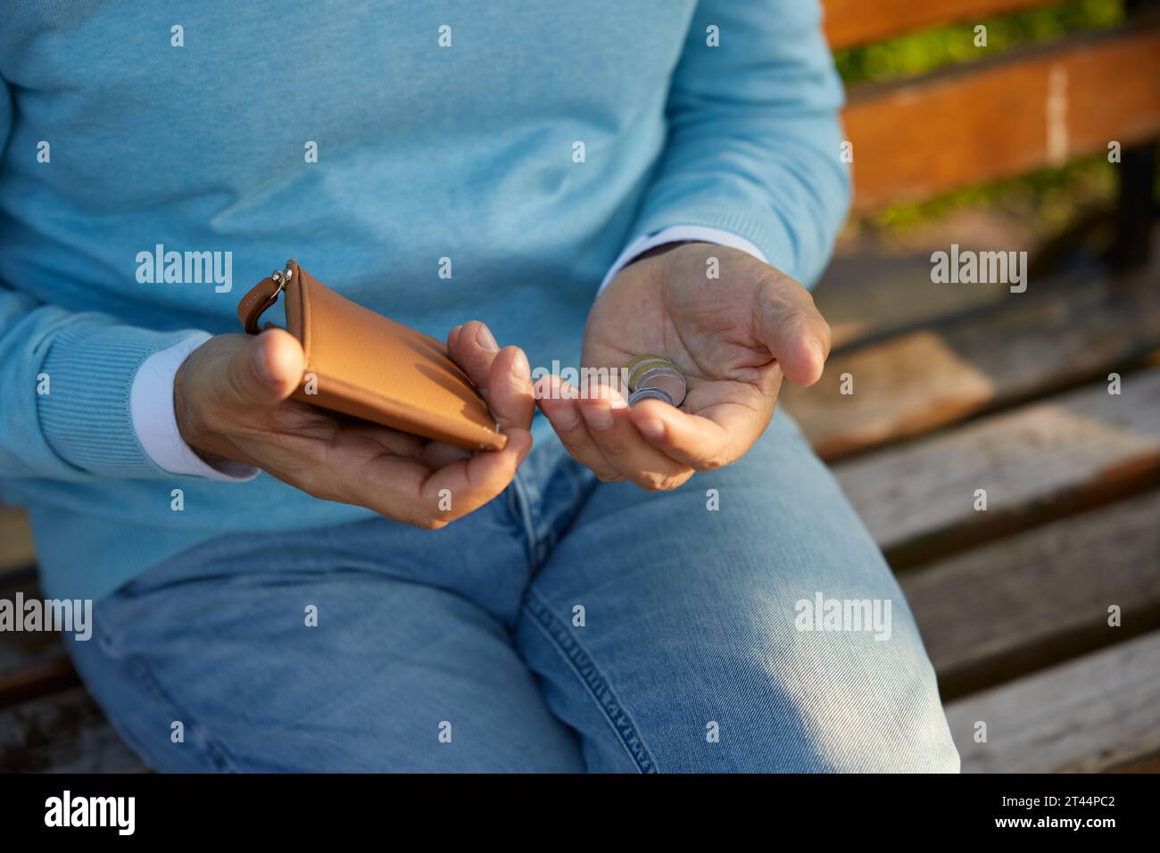 Ein kleiner Schuss von männlichen Händen, die Geldmünzen aus der Brieftasche zählen Stockfoto