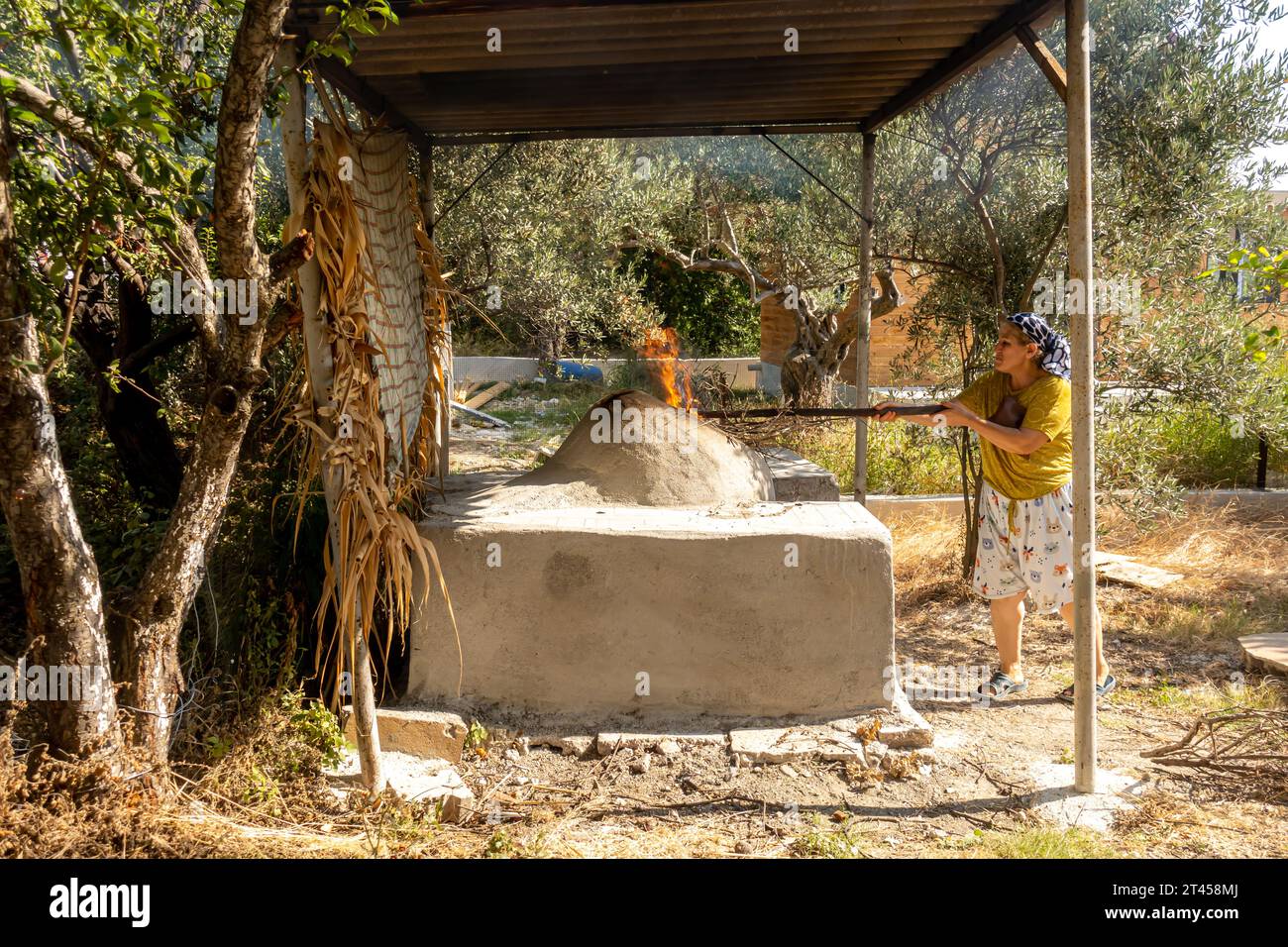 Türkische Frauen backen Brot im traditionellen Brotbackofen in einem Dorf Samandağ in der Provinz Hatay, Türkei Stockfoto