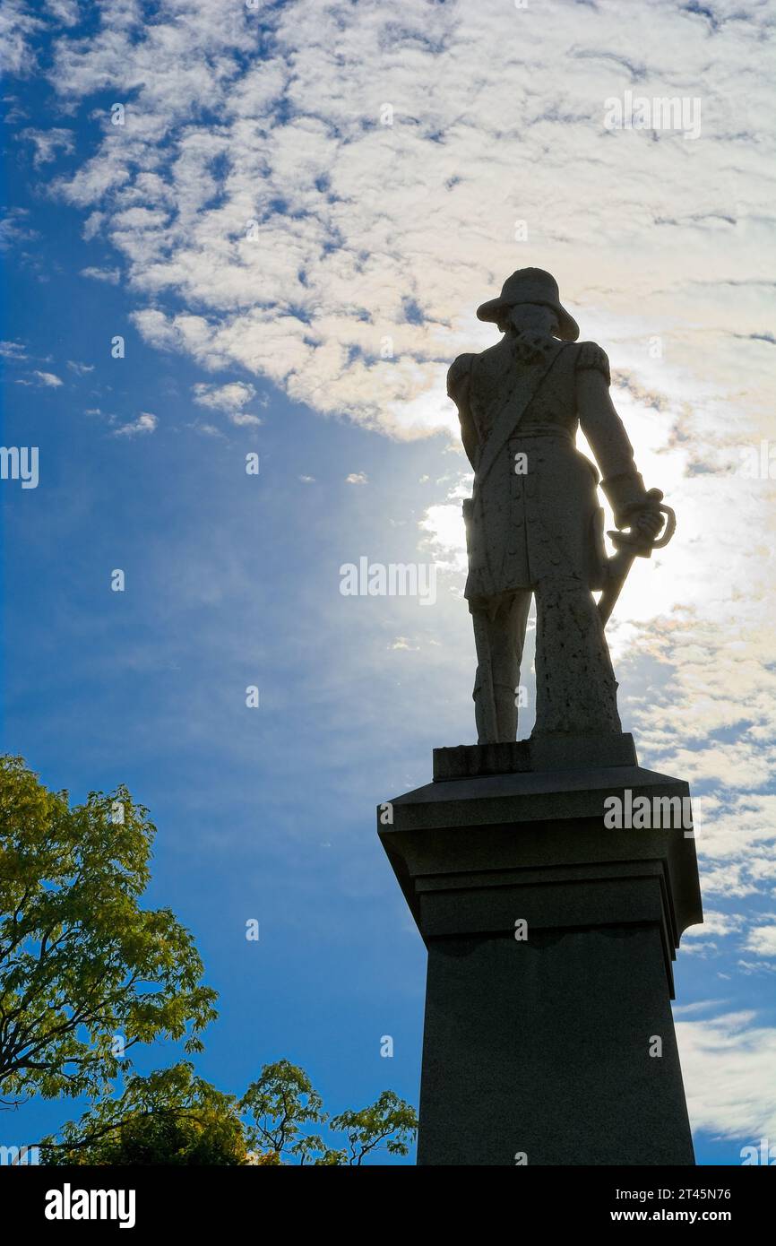 Silhouette 1911 Granit-Statue von Colonel Seth Warner hell hinterleuchtet mit Wolkenhimmel — Bennington, Vermont, Oktober 202 Stockfoto