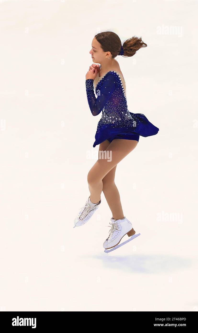 Teenager-Mädchen, das Eiskunstlauf auf einer Eislaufbahn übt Stockfoto