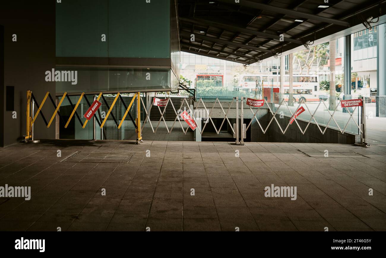 Städtische Barrikade mit mehreren „Keep out“- und „No Looitering or eat“-Schildern, Warnbarrieren, eingeschränkter Bereich, No Entry, Sicherheitsmaßnahmen, Vorschriften Stockfoto