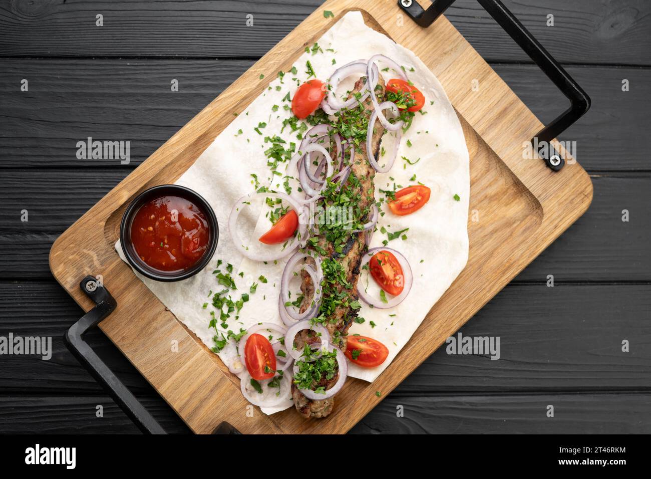 Saftiger heißer lula-Kebab aus Fleisch und Gewürzen. Serviert Gerichte in einem Restaurant auf Pita, über Holzbrett, Blick von oben. Georgische Küche Stockfoto
