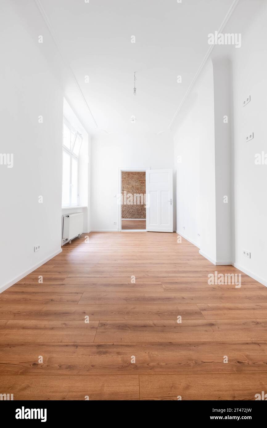 Leeres Zimmer mit Holzboden in neuer Wohnung nach der Renovierung Stockfoto