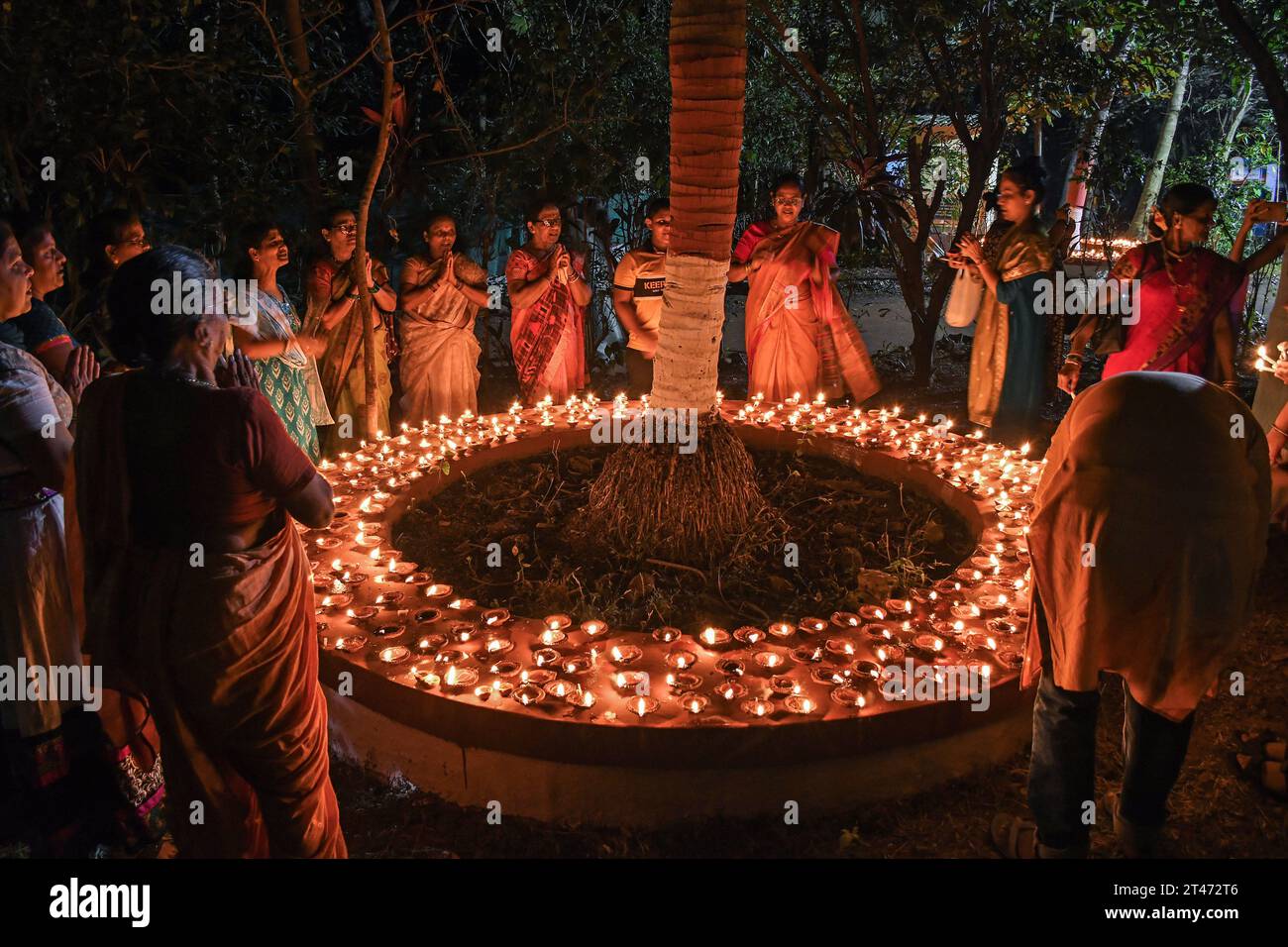 Mumbai, Indien. Oktober 2023. Frauen bilden einen Kreis und beten in der Nähe der irdenen Lampen, die anlässlich der Sharad Purnima (Vollmond) in Mumbai beleuchtet werden. Sharad Purnima oder der Vollmond markiert das Ende der Monsunsaison und wird von den Hindus in ganz Südasien in den Monaten September bis Oktober auf vielfältige Weise gefeiert. Gläubige beobachten in der Vollmondnacht schnell. Lakshmi, Göttin des Reichtums, wird an diesem Tag verehrt, da es ihr Geburtstag sein soll, und zu ihr zu beten bringt Glück und Reichtum. Quelle: SOPA Images Limited/Alamy Live News Stockfoto