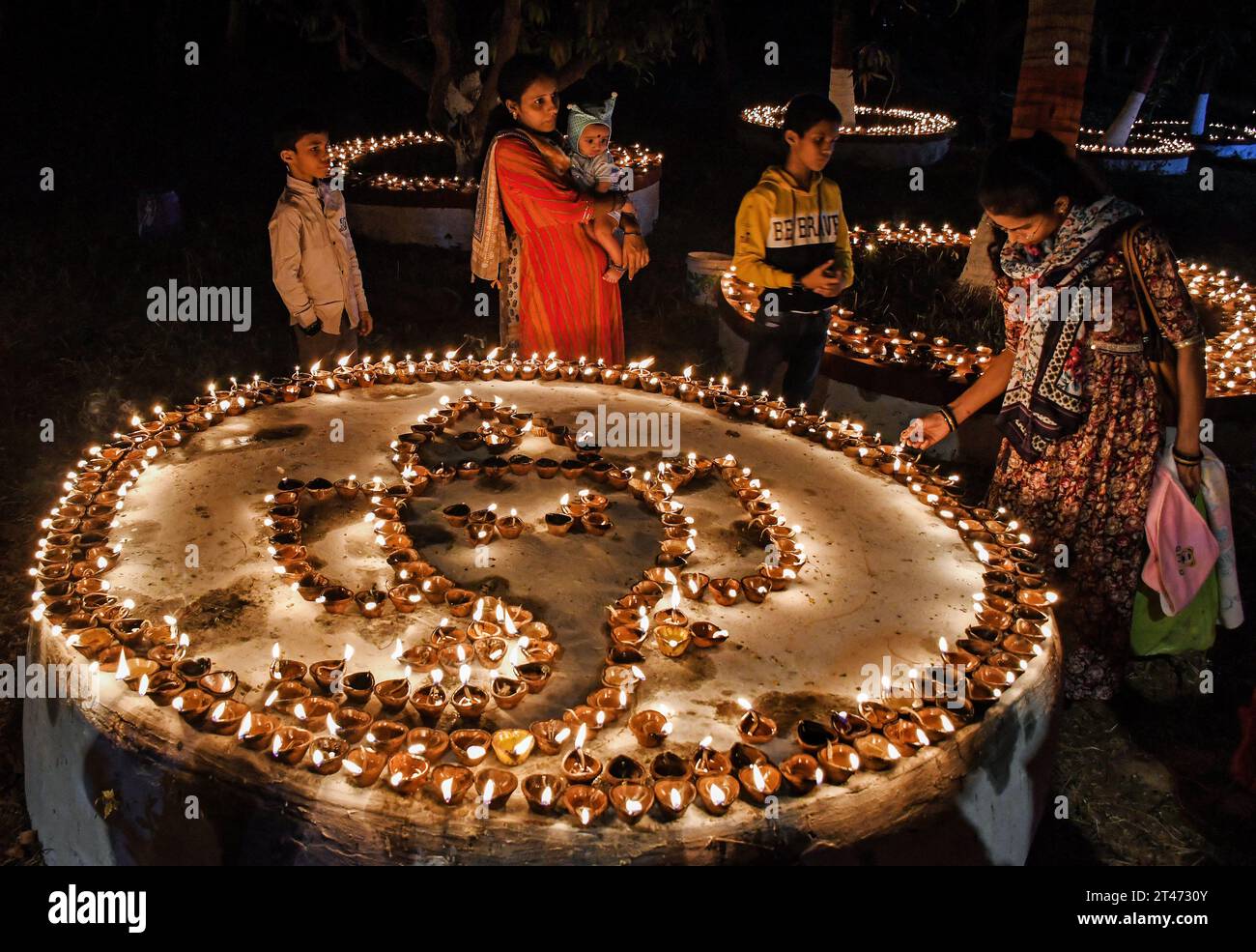 Mumbai, Indien. Oktober 2023. Menschen werden um die Erdlampen herum gesehen, die anlässlich des Sharad Purnima (Vollmond) in Mumbai beleuchtet wurden. Sharad Purnima oder der Vollmond markiert das Ende der Monsunsaison und wird von den Hindus in ganz Südasien in den Monaten September bis Oktober auf vielfältige Weise gefeiert. Gläubige beobachten in der Vollmondnacht schnell. Lakshmi, Göttin des Reichtums, wird an diesem Tag verehrt, da es ihr Geburtstag sein soll, und zu ihr zu beten bringt Glück und Reichtum. (Foto: Ashish Vaishnav/SOPA Images/SIPA USA) Credit: SIPA USA/Alamy Live News Stockfoto