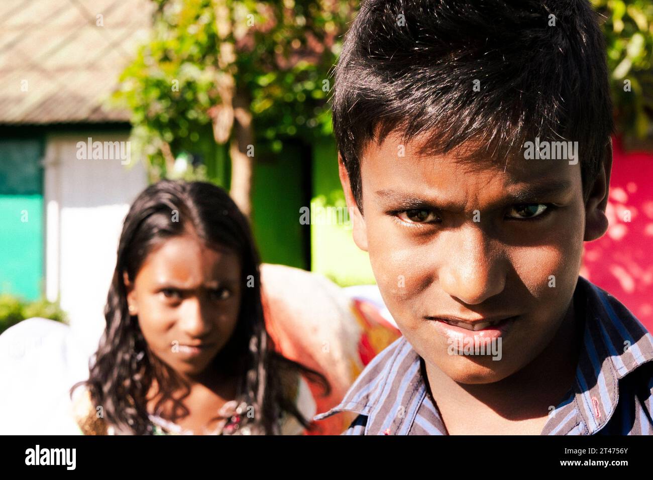 Zwei junge Sri-lankische Kinder schauen direkt in die Kamera in ein kleines Dorf in der Nähe von Nuwara Eliya in Sri Lanka Stockfoto