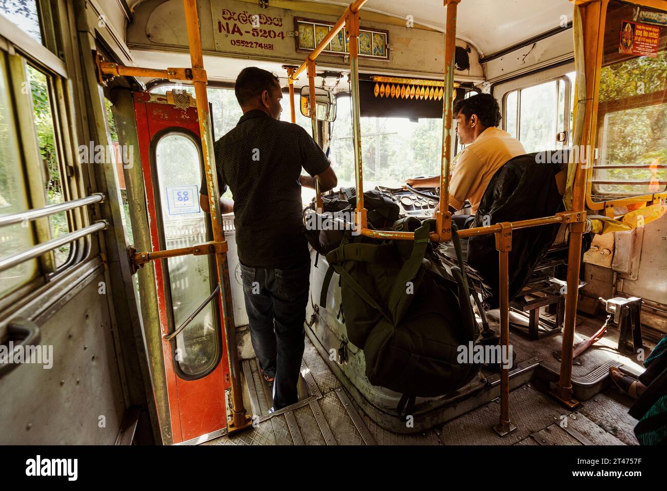 Ein Mann unterhält sich mit dem örtlichen Busfahrer, während er die hügeligen Straßen in Sri Lanka überquert Stockfoto