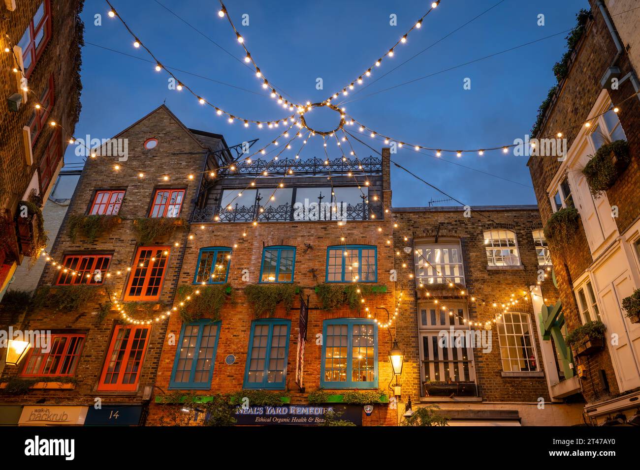 London, Großbritannien: Neal's Yard im Covent Garden-Viertel im Zentrum von London. Blick auf wunderschöne alte Gebäude mit Deckenleuchten bei Nacht. Stockfoto