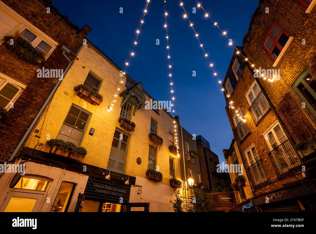 London, Großbritannien: Neal's Yard im Covent Garden-Viertel im Zentrum von London. Ein wunderschöner alter Innenhof bei Nacht, beleuchtet mit Deckenleuchten. Stockfoto