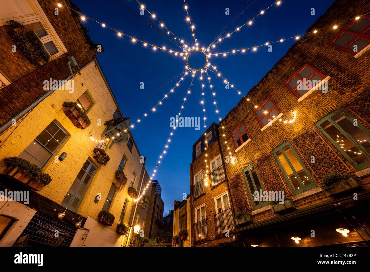 London, Großbritannien: Neal's Yard im Covent Garden-Viertel im Zentrum von London. Ein wunderschöner alter Innenhof bei Nacht, beleuchtet mit Deckenleuchten. Stockfoto