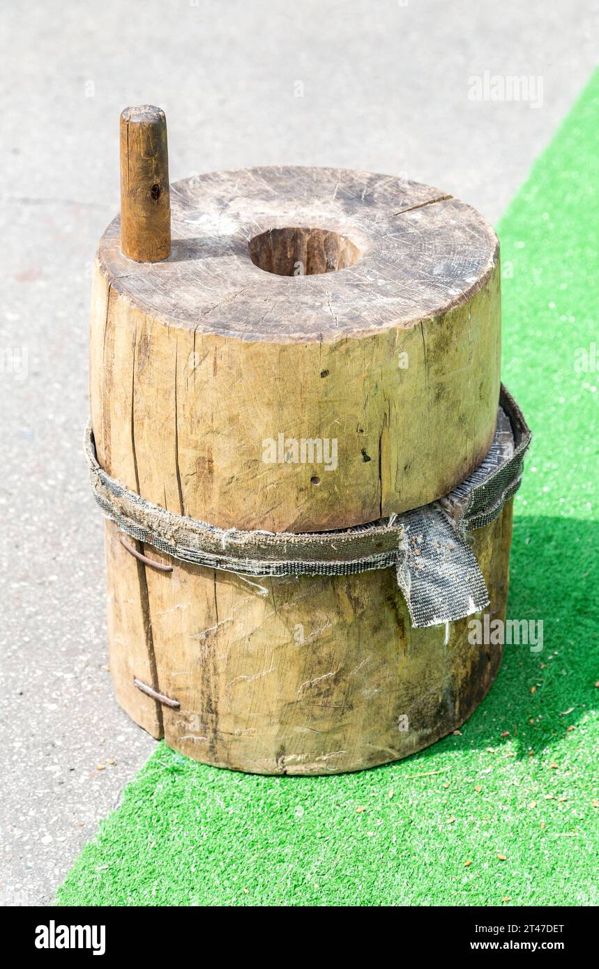 Hölzerne Rotationsmühle zum handmahlen eines Getreides zu Mehl. Alte handbetriebene Mühle, die Weizen mahlt. Vintage-Handmühle Stockfoto