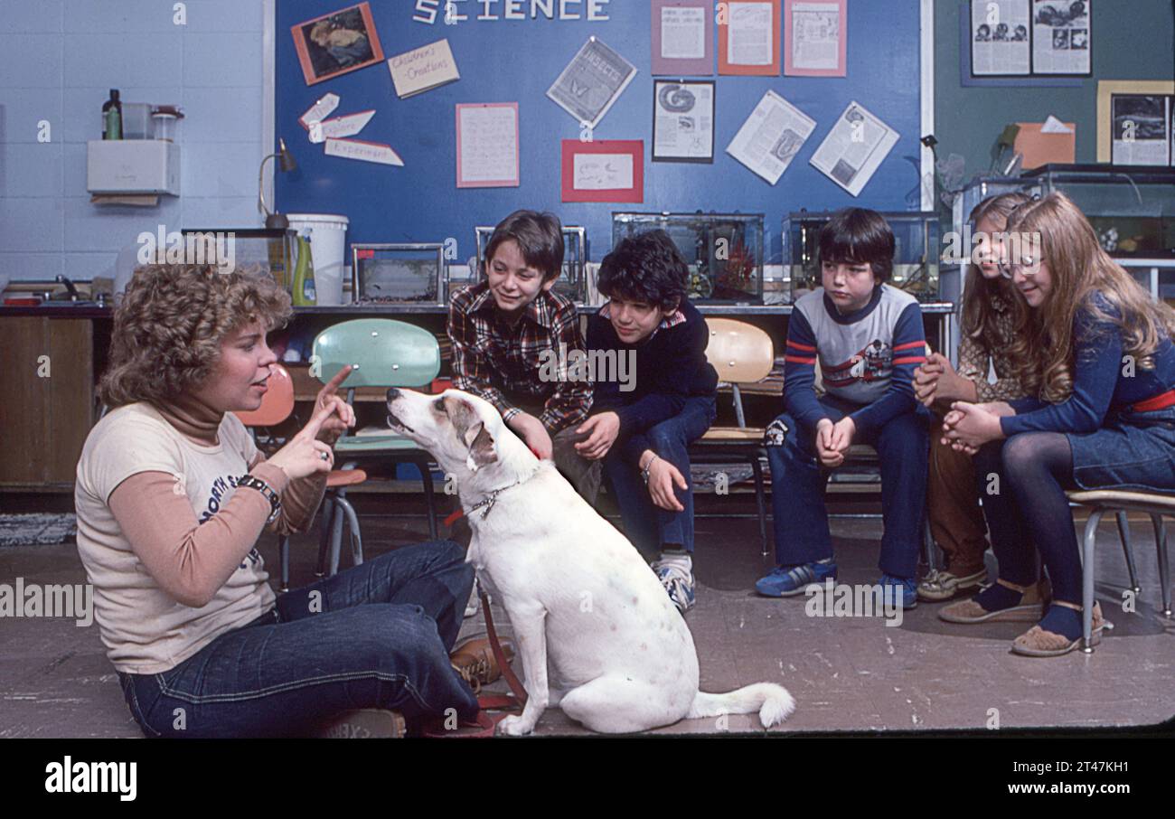 Ein taubes Mädchen, das ihrem Hund beigebracht hat, Befehle in Gebärdensprache zu befolgen. 1982 demonstrierte sie dies für einen Long Island Klassenzimmer. Stockfoto