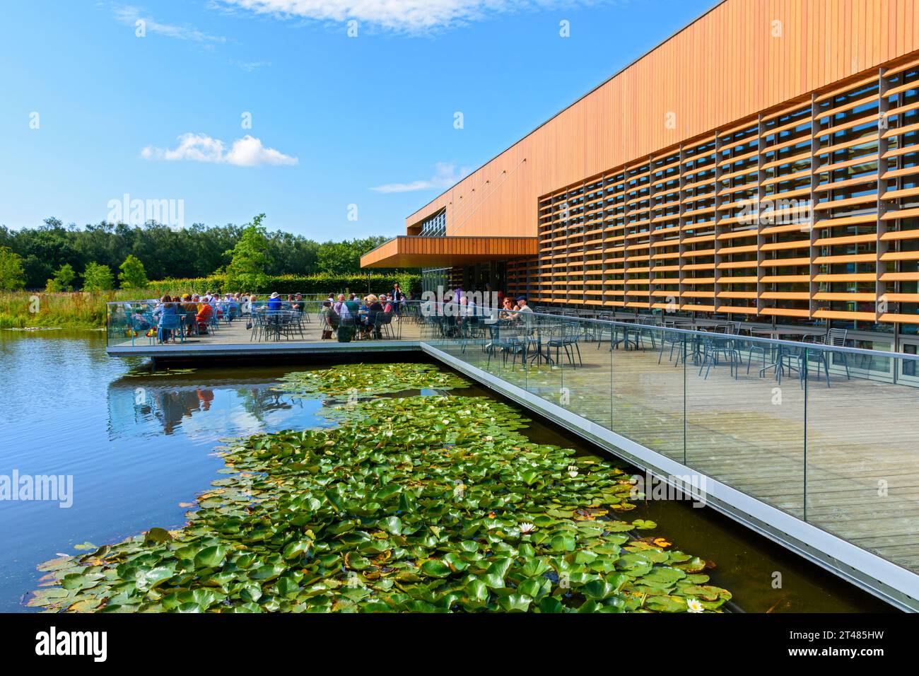 Das Welcome Building über dem Moon Bridge Water Lake, RHS Bridgewater Gardens, Worsley, Salford, Greater Manchester, UK Stockfoto